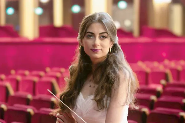 تحمل العصا البيضاء أثناء قيادتها الأوركسترا (أمل القرمازي)