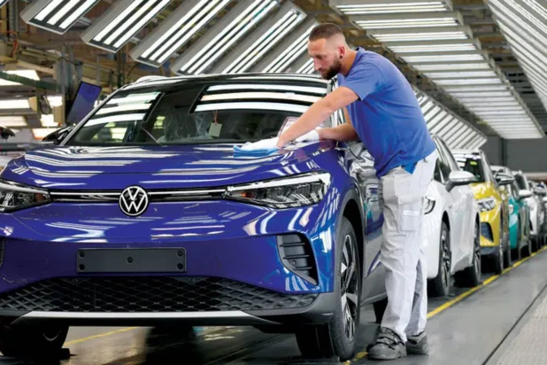 فني يعمل على الفحص النهائي في خط الإنتاج لطراز «فولكس فاغن» الكهربائي (رويترز)