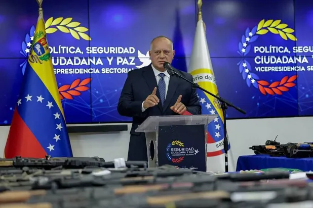 وزير الداخلية الفنزويلي ديوسدادو كابيو يعرض الأسلحة التي صادرتها السلطات بعد اعتقال مواطنين أميركيين وإسبان (أ.ف.ب)