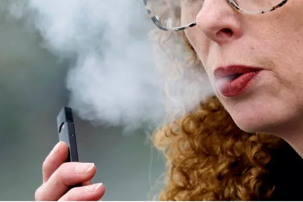 سيدة تدخن سيجارة إلكترونية في مدينة فانكوفر في كندا (أرشيفية - أ.ب)