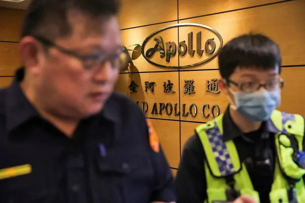 الشرطة التايوانية لحظة وصولها إلى مكتب «غولد أبولو» في مدينة تايبيه صباح اليوم (رويترز)