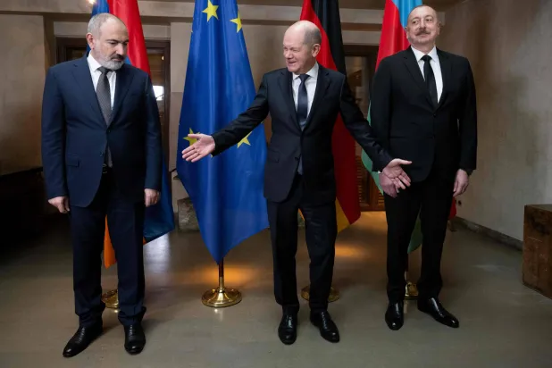 المستشار الألماني أولاف شولتس بين رئيس الوزراء الأرميني نيكول باشينيان (يمين) والرئيس الأذربيجاني إلهام علييف في ميونيخ يوم 17 فبراير (أ.ف.ب)