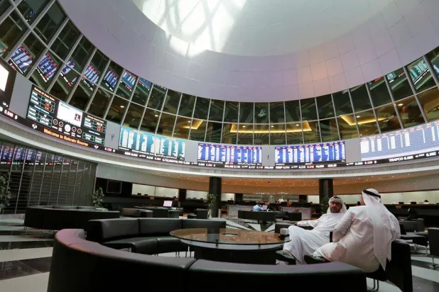 مستثمرون ينظرون إلى الشاشات في بورصة البحرين في المنامة (رويترز)
