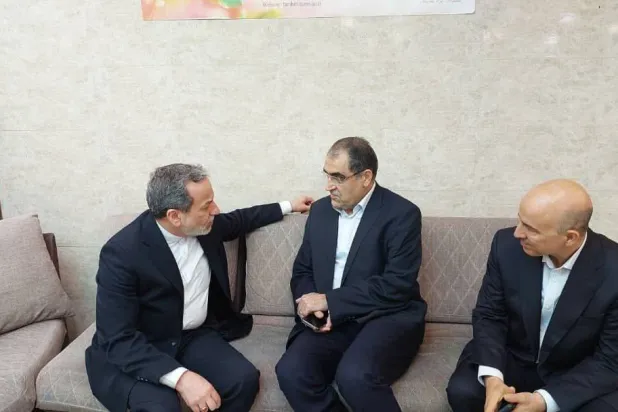 عراقجي يتحدث إلى وزير الصحة السابق حسن قاضي زاده هاشمي الذي يشرف على علاج السفير الإيراني لدى لبنان في مستشفى بطهران