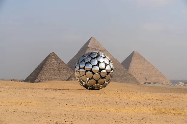 عمل معاصر يتحاور بصرياً مع الأهرامات (أ.ف.ب)