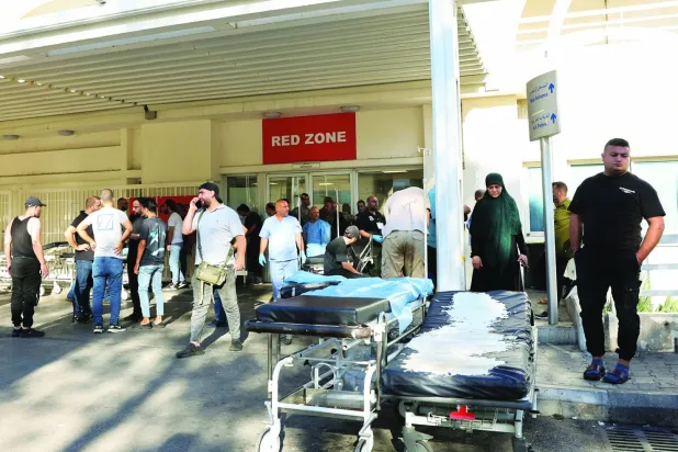 لبنانی‌ها در مقابل بیمارستان رفیق حریری در بیروت جمع شده‌اند، جایی که صدها زخمی به دلیل نقض امنیتی که دستگاه‌های بی‌سیم اعضای «حزب‌الله» را هدف قرار داده بود، منتقل شدند (رویترز)