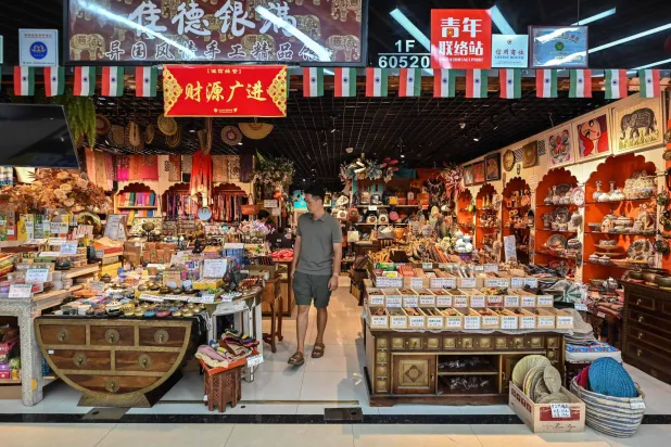 رجل يزور متجراً للسلع الهندية في سوق ييوو بمقاطعة تشجيانغ شرق الصين (أ.ف.ب)