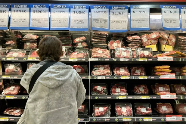 سيدة تتحقق من أسعار لحوم البقر في أحد المتاجر الكبرى في بوينس آيرس (أ.ف.ب)