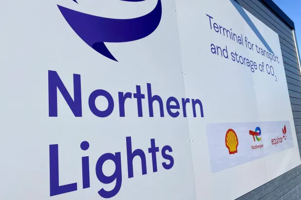 لوحة إعلانية تحمل شعارات مشروع ثاني أكسيد الكربون في «نورثرن لايتس» وشركات أخرى خارج المنشأة في أويغاردن (رويترز)