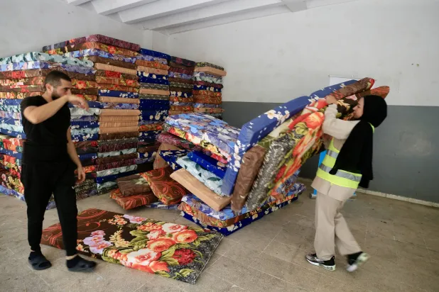 متطوعون يقومون بإعداد ملاجئ للأشخاص الذين فروا من جنوب لبنان في أعقاب الضربات العسكرية الإسرائيلية في الأيام الأخيرة (إ.ب.أ)