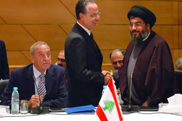 أرشيفية تظهر نصر الله مصافحاً النائب جورج عدوان (القوات اللبنانية) في إحدى جلسات الحوار اللبناني عام 2006 برئاسة بري (أ.ف.ب)