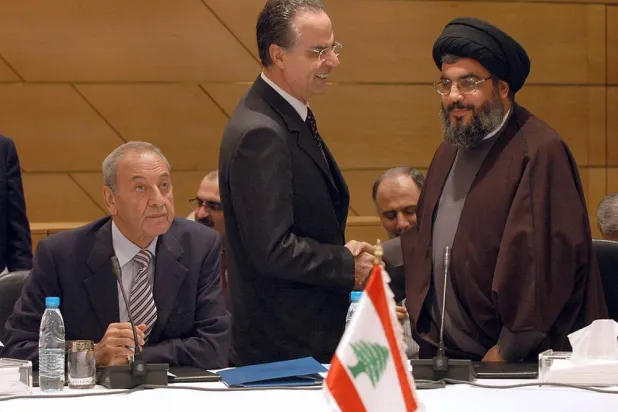 Lebanese Forces MP Georges Adwan (C) shakes hands with Hezbollah's chief Hassan Nasrallah parliament Speaker Nabih Berri looks on during a meeting that brought together parties from across Lebanon's fractious political spectrum, in Beirut on March 3, 2006. (AFP) 