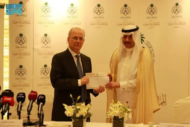 Saudi Ambassador to Jordan and Non-resident Ambassador to Palestine Naif Al-Sudairi hands the financial aid to Palestinian Prime Minister Mohammed Mustafa on Sunday. (SPA)
