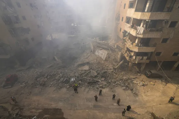 رجال الإنقاذ يعملون في موقع غارة جوية إسرائيلية بالضاحية الجنوبية ببيروت اليوم (أ.ب)