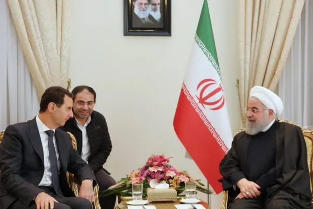 محمد جعفر قصير خلال اجتماع بين الرئيس السوري بشار الأسد والرئيس الإيراني السابق حسن روحاني في دمشق (أرشيفية - غيتي)