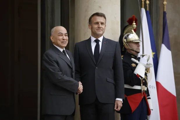 الرئيس إيمانويل ماكرون مستقبلاً الخميس على مدخل قصر الإليزيه ملك كمبوديا نورودوم سيهاموني قبل يوم من افتتاح القمة الفرنكوفونية (إ.ب.أ)