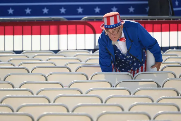 متطوّع ينهي الاستعدادات لفعالية ترمب في بتلر ببنسلفانيا مرتدياً زيّ «العم سام» يوم 5 أكتوبر (أ.ف.ب)