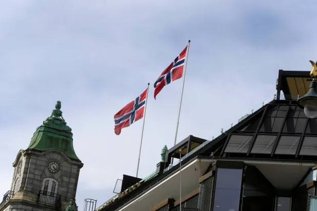 أعلام النرويج ترفرف فوق مبنى في أوسلو (رويترز)