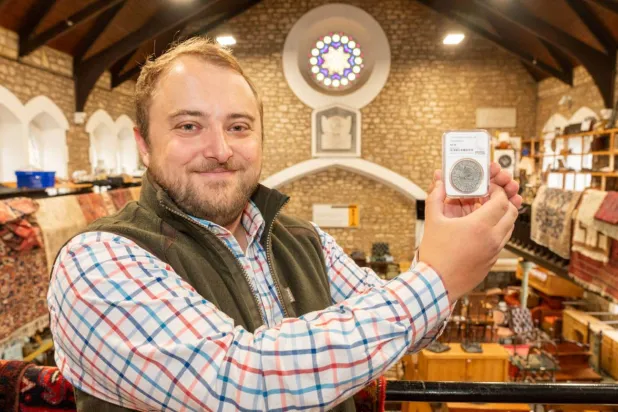 خبير المزادات جوزيف تريندر يعرض العملة (مزاد ووتن أوكشن رومز)