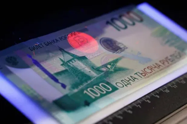 ورقة نقدية من فئة 1000 روبل داخل جهاز كشف العملات خلال عرض تقديمي في موسكو (رويترز)