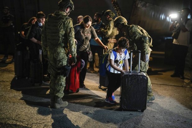 Turkish citizens walk to board Turkish military ships evacuating them from Lebanon to Türkiye, in Beirut port on Wednesday, Oct. 9, 2024. (AP Photo/Emrah Gurel)
