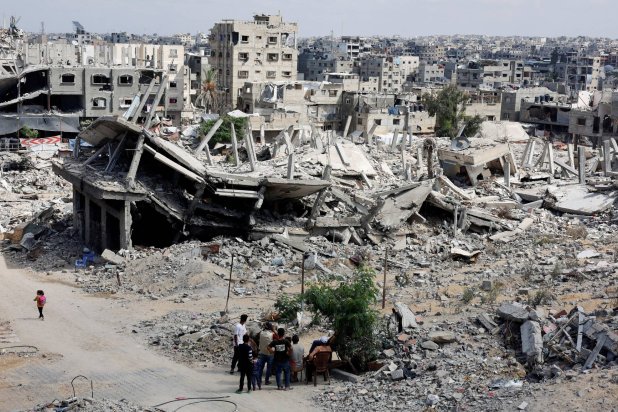 FILE PHOTO: Palestinians sit next to the rubble of houses destroyed in Israel's military offensive, amid the ongoing conflict between Israel and Hamas, in Khan Younis in the southern Gaza Strip October 7, 2024. REUTERS/Mohammed Salem/File Photo