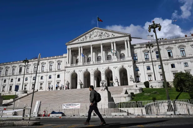 رجل يمرّ أمام البرلمان البرتغالي في لشبونة (أ.ف.ب)