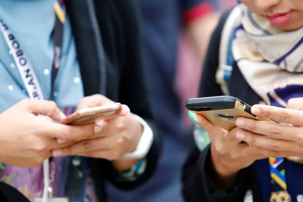 تحوّلت الهواتف الذكية بما فيها من تطبيقات إلى إدمان العصر (رويترز)
