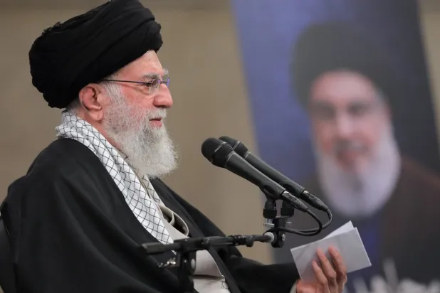 خامنئي يلقي خطاباً أمام مجموعة من أنصاره وفي الخلفية صورة نصر الله (موقع المرشد) 