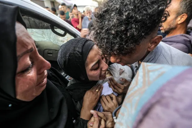 Nuseyrat Mülteci Kampı’nda Filistinlilerin barındığı bir okula yapılan saldırıda öldürülen bebeği için ağlayan Filistinli bir kadın (EPA)