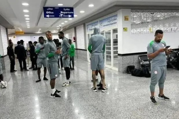 لاعبو منتخب نيجيريا خلال التأهب للعودة لبلادهم بعد بقائهم ساعات في مطار الأبرق (إكس)