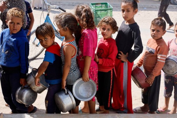  Palestinian children queue to receive food cooked by a charity kitchen, amid the Israel-Hamas conflict, in Khan Younis in the southern Gaza Strip, October 16, 2024. (Reuters)