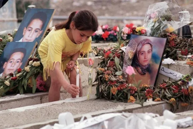 طفلة تضيء شمعة عن أرواح أفراد عائلتها الذين سقطوا ضحايا مجزرة قانا الأولى