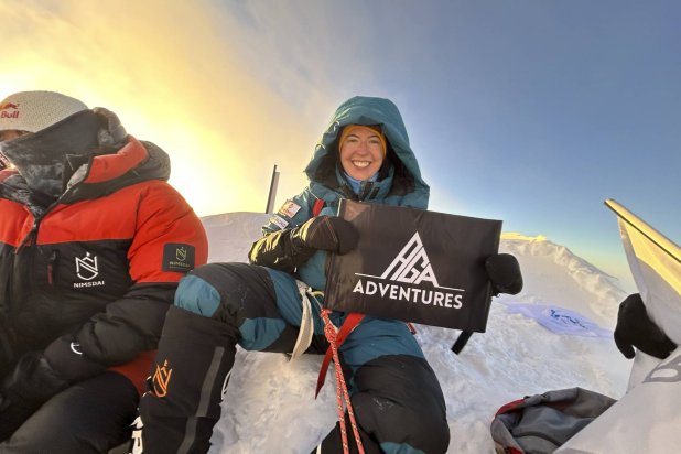 Adriana Brownlee, 23, youngest woman to scale all the world's 14 highest peaks, poses for a photograph at the summit of Shishapangma Tibet, Wednesday, Oct. 9, 2024. (AGA Adventures via AP)