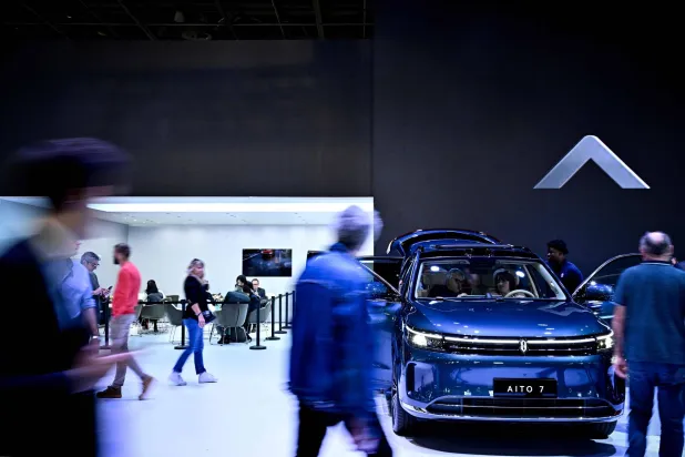 زوار في «معرض باريس الدولي للسيارات» يشاهدون سيارة «أيتو 7» الصينية الكهربائية داخل إحدى القاعات (أ.ف.ب)
