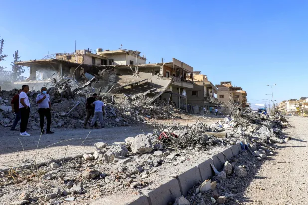 لبنانيون يتفقدون مبنى مدمراً بغارات إسرائيلية في دورس جنوب مدينة بعلبك (أ.ف.ب)