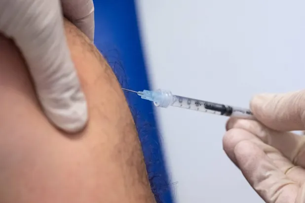 عامل بالقطاع الطبي يحقن شخصاً بلقاح ضد جدري القردة في ميونيخ (د.ب.أ)