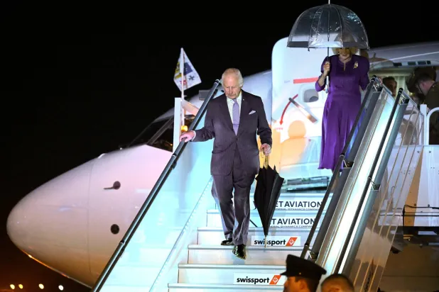 الملك تشارلز والملكة كاميلا يخرجان من الطائرة لدى وصولهما إلى مطار سيدني (رويترز)