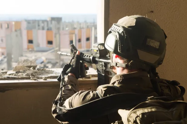 جندي إسرائيلي يطلق النار من داخل إحدى البنايات في قطاع غزة (موقع الجيش الإسرائيلي)