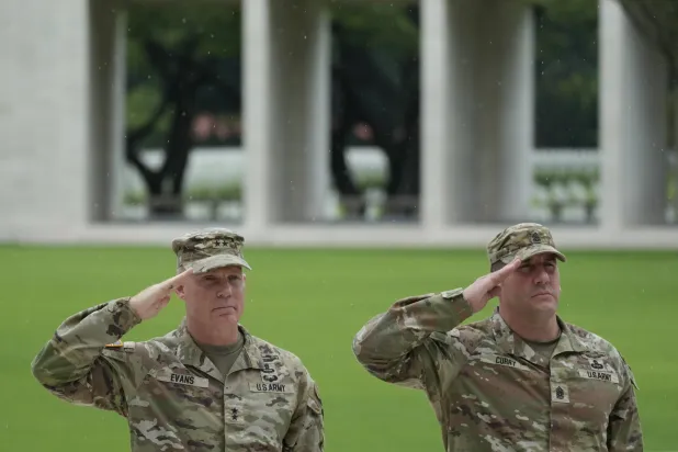 اللواء ماركوس إيفانز القائد العام للفرقة الخامسة والعشرين للمشاة في الجيش الأميركي (يسار) والرقيب أول شون كاري يؤديان التحية العسكرية خلال مراسم وضع إكليل الزهور لتكريم الجنود الأميركيين الذين لقوا حتفهم خلال الحرب العالمية الثانية بمقبرة مانيلا الأميركية بالفلبين الاثنين (أ.ب)