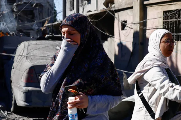 لبنانيتان في موقع غارة إسرائيلية قرب مستشفى رفيق الحريري في بيروت (رويترز)