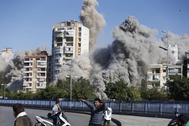 أشخاص يفرون بعد غارة إسرائيلية على منطقة الضاحية الجنوبية في بيروت بلبنان يوم 22 أكتوبر 2024 (إ.ب.أ)