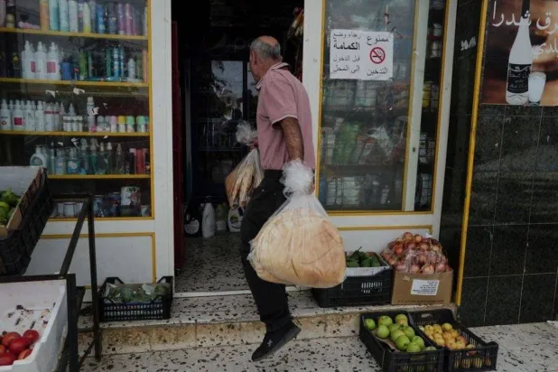 A man carries bread to sell at his shop in the southern town of Rmeish (Reuters)