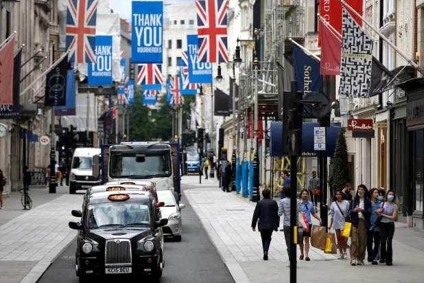 أشخاص يسيرون على طول شارع نيو بوند في لندن (رويترز)