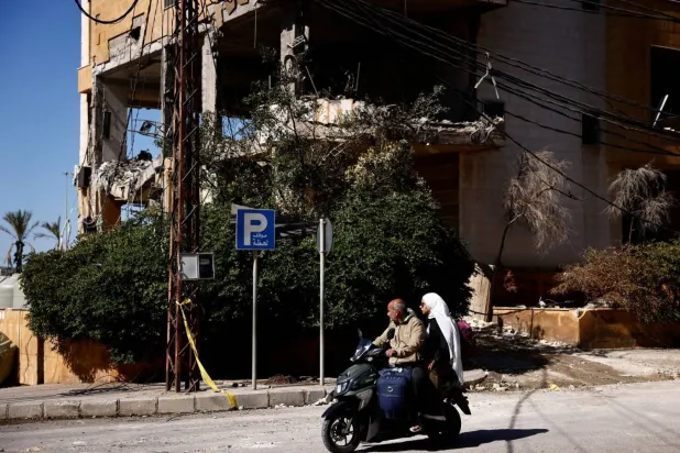 People ride a motorcycle near the site of an Israeli strike that destroyed an office used by Al-Mayadeen broadcaster, amid ongoing hostilities between Hezbollah and Israeli forces, in Beirut suburbs, Lebanon October 24, 2024. REUTERS/Yara Nardi