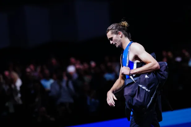 زفيريف في طريقه إلى خارج الملعب عقب خسارته المباراة (د.ب.أ)