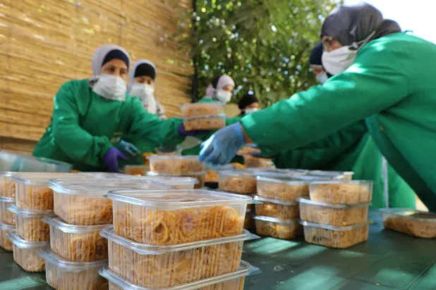 متطوعون يعدون وجبات الطعام للنازحين إلى مراكز إيواء مؤقتة في بعلبك بشرق لبنان (أ.ف.ب)