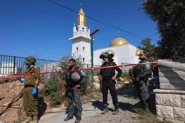 جنود إسرائيليون يتفقدون موقعاً سقط به صاروخ من «حزب الله» في شمال إسرائيل الثلاثاء (أ.ف.ب)