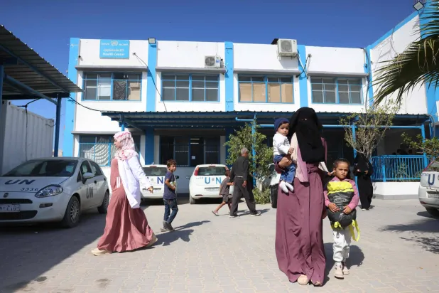فلسطينيون يسيرون في ساحة المركز الصحي الياباني التابع لـ«الأونروا» في خان يونس جنوب قطاع غزة في 29 أكتوبر 2024 وسط الحرب المستمرة بين إسرائيل و«حماس» (أ.ف.ب)