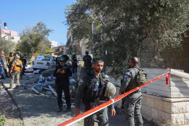 İsrail güvenlik personeli, İsrail'in kuzeyinde Hizbullah füzelerinin düştüğü bölgeyi inceliyor (AFP)